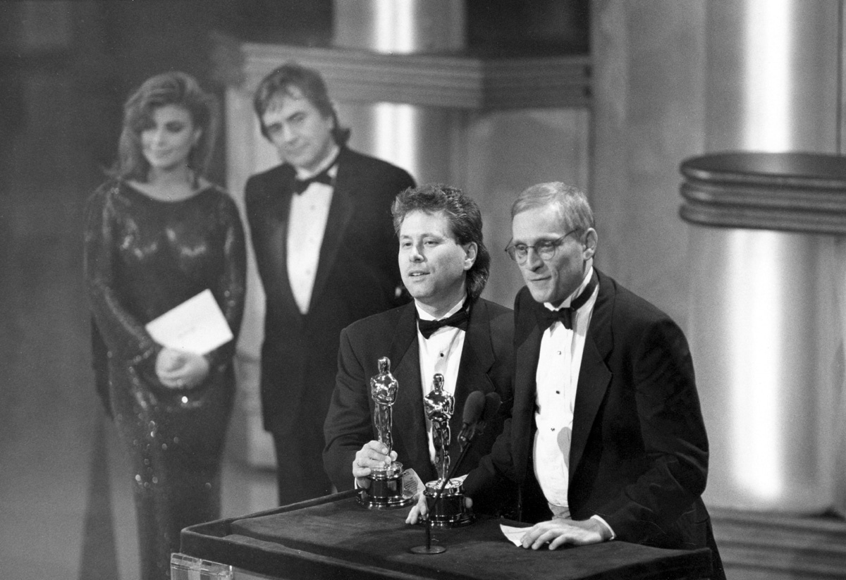 Alan Menken (music) and Howard Ashman (lyrics) accept their Oscars for Best Original Song for "Under the Sea," from the film THE LITTLE MERMAID (1989). Behind them are presenters Paula Abdul and Dudley Moore. Credit: Long Photography / ©A.M.P.A.S.